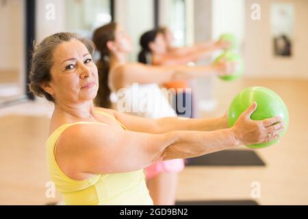 Reife weibliche Durchführung Satz von Übungen mit Pilates Ball Stockfoto