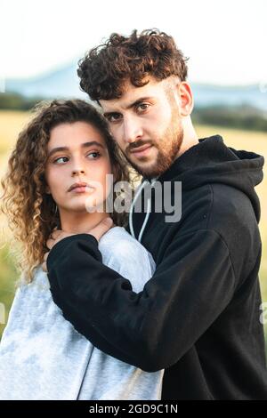 Schönes heterosexuelles Paar auf einem Grasfeld, das herumläuft und küsst Stockfoto