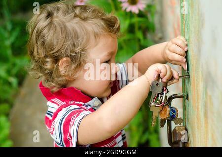 Kleiner Junge mit Schlüsseln im Freien Stockfoto