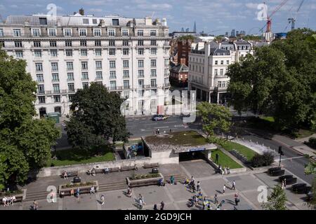 Von der Anhöhe des Marble Arch Mound aus gesehen, befindet sich ein Eingang der U-Bahnstation Marble Arch und das nördliche Ende der Park Lane am 11. August 2021 in London, England. Stockfoto