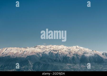 Schneebedeckte Bergkette vor dem tiefblauen Himmel. Stockfoto