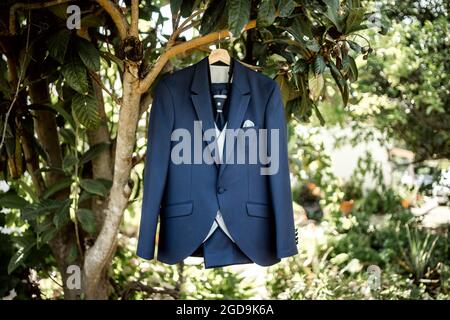 Eleganter dunkelblauer Anzug mit Weste und Bindeband am Baum Stockfoto