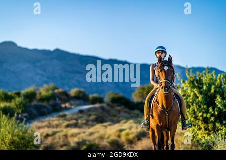 Junge Frau genießt Reiten in der bergigen Wildnis von Andalusien, Spanien Stockfoto