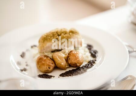 Traditionelle portugiesische Mahlzeit aus gebackenem Kabeljau serviert mit gebackenen Kartoffeln Stockfoto