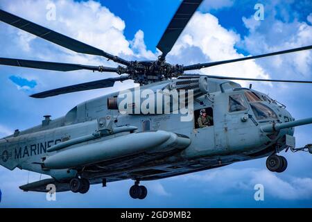 U.S. Marine Corps Lance CPL. Anthony Corcoran, ein Ch-53E-Crewchef mit Marine Medium Tiltrotor Squadron 265 (verstärkt), 31. Marine Expeditionary Unit (MEU), bereitet sich auf die Landung an Bord des amphibischen Angriffsschiffs USS America (LHA 6) vor, während der Talisman Sabre 21 am 24. Juli 2021. Der CH-53E bietet Kampfkommandanten erweiterte Reichweite und Schwerlastfähigkeiten für eine Vielzahl von Missionen. Australische und US-Streitkräfte vereinen sich alle zwei Jahre für Talisman Sabre, eine einmonatige Multi-Domain-Übung, die die Fähigkeiten von Alliierten und Partnern stärkt, um auf das gesamte Spektrum von Indo-Pacific Secur zu reagieren Stockfoto