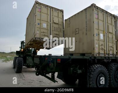 Segler des Navy Cargo Handling Battalion ONE entladen im Rahmen einer groß angelegten Übung (LSE 2021) am 7. August 2021 die Ausrüstung für das Distributed Littoral Operational Fuel Transfer System (DLOFTS) auf Onslow Beach, N.C. LSE 2021 demonstriert die Fähigkeit der Marine, weltweit präzise, tödliche und überwältigende Gewalt über drei Seestreitkommandos, fünf nummerierte Flotten und 17 Zeitzonen hinweg einzusetzen. LSE 2021 vereint Live- und synthetische Trainingsfunktionen, um eine intensive, robuste Trainingsumgebung zu schaffen. Es wird eine Verbindung zwischen High-Fidelity-Schulungen und realen Operationen herstellen, um die erforderlichen Kenntnisse und Fähigkeiten zu erwerben Stockfoto