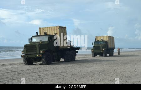 Segler des Navy Cargo Handling Battalion ONE entladen im Rahmen einer groß angelegten Übung (LSE 2021) am 7. August 2021 die Ausrüstung für das Distributed Littoral Operational Fuel Transfer System (DLOFTS) auf Onslow Beach, N.C. LSE 2021 demonstriert die Fähigkeit der Marine, weltweit präzise, tödliche und überwältigende Gewalt über drei Seestreitkommandos, fünf nummerierte Flotten und 17 Zeitzonen hinweg einzusetzen. LSE 2021 vereint Live- und synthetische Trainingsfunktionen, um eine intensive, robuste Trainingsumgebung zu schaffen. Es wird eine Verbindung zwischen High-Fidelity-Schulungen und realen Operationen herstellen, um die erforderlichen Kenntnisse und Fähigkeiten zu erwerben Stockfoto