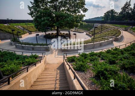 Ansicht des New Jersey Vietnam Veterans’ Memorial in Holmdel, N.J., 7. Juli 2021. In der Mitte befindet sich die Northern Red Oak, der State Tree von New Jersey, sowie drei Bronzestatuen, die diejenigen darstellen, die nach Hause kamen, die Frauen, die dienten und diejenigen, die nicht zurückkamen. Das Memorial, ein kreisförmiger Freiluftpavillon mit einem Durchmesser von 200 Fuß, wurde von Hien Nguyen entworfen, der 1975 aus Vietnam in die Vereinigten Staaten kam. Sie besteht aus 366 8 Fuß hohen schwarzen Granitplatten, die jeweils einen Tag des Jahres repräsentieren. An dem Tag, an dem sie getötet wurden, sind auf den Granitplatten Verletzte aufgeführt. Der Mai Stockfoto