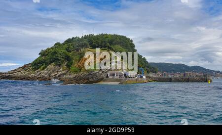 San Sebastian, Spanien - 2. August 2021: Legen Sie an der Isla Santa Clara in der Bucht von La Conca an Stockfoto