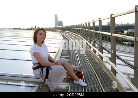 Frau, die auf dem Dach eines Gebäudes in Moskau sitzt Stockfoto