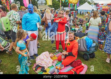 Eine Familie, die bei einem Sommerfest in Superhelden-Kostüme gekleidet ist. Camp Beestival, Lulworth, Dorset, Großbritannien Stockfoto