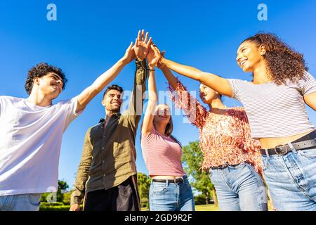 Eine Gruppe von glücklichen Gens z-Freunden, die die Hand berühren, die zueinander erhoben wurde. Konzept von Vertrauen in die Zukunft und Erfolg im Leben. Vielfältige, tausendfach multiethnische Stu Stockfoto