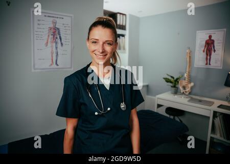 Kaukasische Ärztin, die lächelnd in der Klinik steht Stockfoto