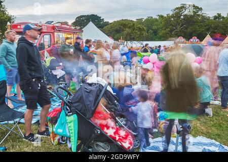 Ein Blick in die Abenddämmerung von Zuschauermassen vor der Hauptbühne des Camp Beestival, einem familienfreundlichen jährlichen Musikfestival in Lulworth, Dorset, Großbritannien Stockfoto