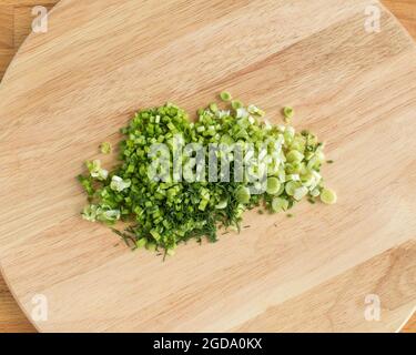 In Scheiben geschnittene grüne Zwiebeln auf einem Schneidebrett.leicht, hell, keine Menschen, niemand, Tag, Tagsüber, Essen, Kochen, Küche Stockfoto