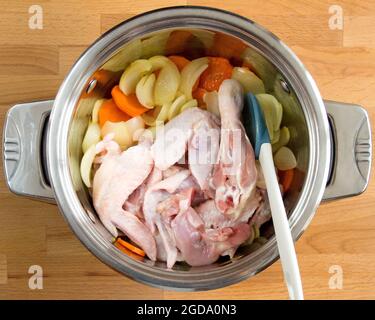 Gemüse und rohes Huhn in einem Topf. Vorbereitung für das Kochen von Brühe. Stockfoto