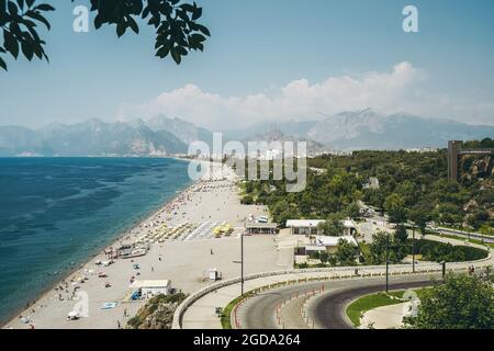 Strand von Konyaalti in Antalya, Türkei. Langer türkischer Strand am Mittelmeer bei warmem, sonnigem Sommerwetter. Rest der Touristen im Badeort. Hochwertige Fotos Stockfoto