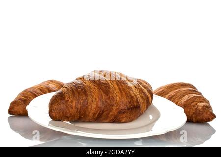 Drei duftende Croissants mit Schokoladenfüllung auf einer weißen Keramikplatte, Nahaufnahme, isoliert auf Weiß. Stockfoto