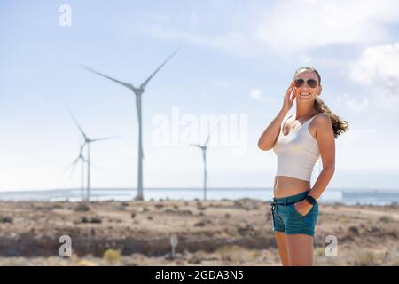 Junge Frau steht in der Nähe der Windmühlenfarm auf Teneriffa Stockfoto