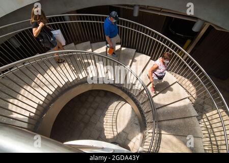 Washington, DC, USA. August 2021. Drei maskierte Personen steigen eine Treppe in Miami, Florida, USA, 11. August 2021. Die US-amerikanischen Centers for Disease Control and Prevention (CDC) veröffentlichten am Mittwoch Gesamtprognosen, die darauf hindeuten, dass die Krankenhauseinweisungen 19 und Todesfälle des Landes in den nächsten vier Wochen voraussichtlich zunehmen werden. Quelle: Monica McGivern/Xinhua/Alamy Live News Stockfoto