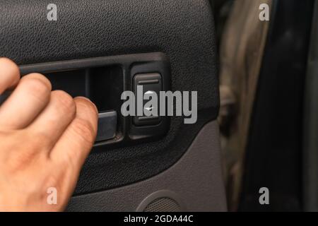 Nahaufnahme einer Männerhand öffnet die Autotür von innen, kopiert den Raum Stockfoto