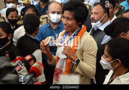 Guwahati, Guwahati, Indien. August 2021. Boxerin Lovlina Borgohain, die bei den Olympischen Spielen in Tokio die Bronzemedaille in der Gewichtsklasse 69 gewann, zeigt ihren Anhängern ihre Bronzemedaille, als sie am Donnerstag, den 12. August 2021, am internationalen Flughafen Lokopriya Gopinath Bordoloi, Borjar in Guwahati Assam Indien ankam. Boxerin Lovlina Borgohain ist die erste Spielerin aus Assam, die bei den Olympischen Spielen eine Medaille gewonnen hat (Bildquelle: © Dasarath Deka/ZUMA Press Wire) Stockfoto