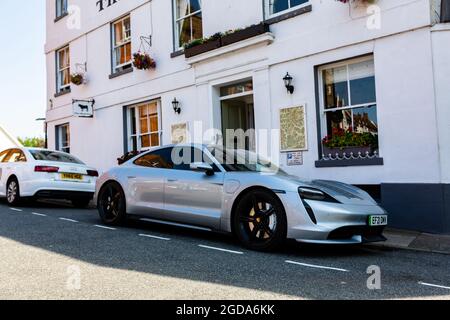 Woodbridge Suffolk UK August 11 2021: Ein elektrischer Porsche Taycan Turbo mit 2021 Modellen parkte auf der Straße vor einem beliebten Hotel in der Marktstadt Wood Stockfoto