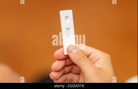 Coronavirus-Selbsttest zu Hause, man Hand hält covid 19 positive Ergebnis Schnelltest, Kit zum Nachweis von Antikörpern und Immunität. Nahaufnahme, Auswahl Stockfoto