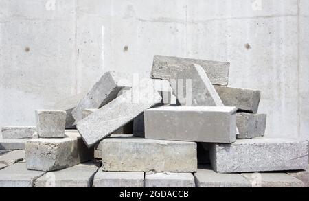 Ein Haufen Zementziegel. Für den Bau wird massiver Ziegel verwendet. Viele lose Betonsteine auf der Baustelle Stockfoto