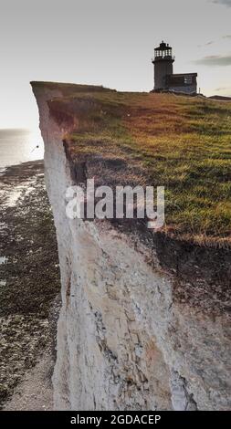 Eastbourne, East Sussex, Großbritannien. August 2021. Weitere große Klippenstürze stehen unmittelbar bevor, nachdem exeptional Regen die hohe Porosität der Kreide geschwächt hat. Neue Bilder zeigen das Ausmaß des natürlichen, aber extrem beschleunigten Phänomens, das die ciffs so makellos weiß hält. Dieses Bild, das 100 Meter östlich des jüngsten großen Falls in der Nähe des Leuchtturms Belle Tout aufgenommen wurde, zeigt deutlich die Unterschneidungen und extreme Fragilität der Felskanten mit Rasen, die Risse verbergen. Das ist auf den Klippen nicht zu sehen und ist typisch entlang der Klippen von Eastbourne bis Seaford. Der Fotograf ging keine Risiken ein Stockfoto