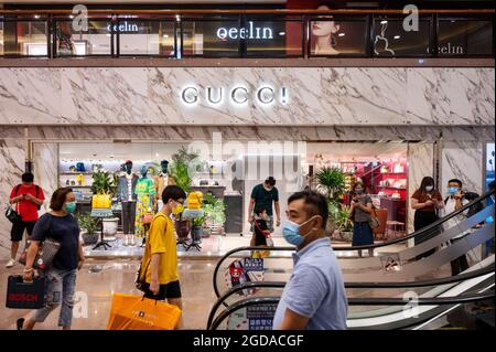 Die Käufer kommen am italienischen Luxusmodemarke Gucci-Logo vorbei und sehen ein Geschäft in Hongkong. Stockfoto