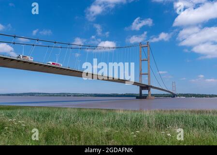 Barton, Linconshire, Großbritannien, 16. Juni 2021 - Lastwagen überqueren die Humber Bridge an einem klaren, sonnigen Tag mit blauem Himmel. Stockfoto