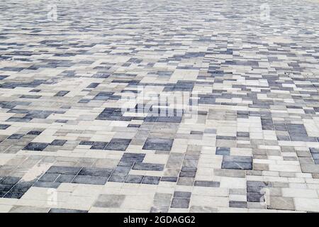 Beton oder gepflasterte, neu verlegte, graue Pflasterplatten oder Steine für Fußböden oder Gehwege. Betonpflaster Platten im Hinterhof oder Straßenpflaster. Garten Ziegel pa Stockfoto