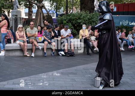 Da viele Menschen und Familien während der Schulferien in Großbritannien ihren Sommerurlaub verbringen, ist eine große Anzahl von Inlandstouristen, Wer normalerweise ins Ausland gereist ist, hat sich in der Hauptstadt decendiert, um die Sehenswürdigkeiten zu sehen, wie man hier am Leicester Square sieht, als ein Darth Vader Touristen erwartet, mit denen sie am 10. August 2021 in London, Großbritannien, fotografiert werden können. Nach dem Coronavirus/Covid-19-Gesundheitsproblem der letzten zwei Jahre und mit noch einigen Reisebeschränkungen haben sich mehr Menschen für einen Aufenthalt entschieden, der ein Urlaub im Heimatland ist, anstatt im Ausland, oder einen Stockfoto