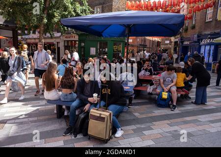 Da viele Menschen und Familien während der Schulferien in Großbritannien ihren Sommerurlaub verbringen, ist eine große Anzahl von Inlandstouristen, Wer normalerweise ins Ausland gereist ist, hat sich in der Hauptstadt decendiert, um die Sehenswürdigkeiten zu sehen, wie man sie hier in Chinatown am 10. August 2021 in London, Großbritannien, sieht. Nach dem Coronavirus/Covid-19-Gesundheitsgeplage der letzten zwei Jahre und mit noch einigen Reisebeschränkungen haben sich immer mehr Menschen für einen Aufenthalt entschieden, der ein Urlaub im Heimatland ist, anstatt im Ausland, oder einen Urlaub zu Hause und mit Tagesausflügen zu lokalen Attraktionen. Stockfoto