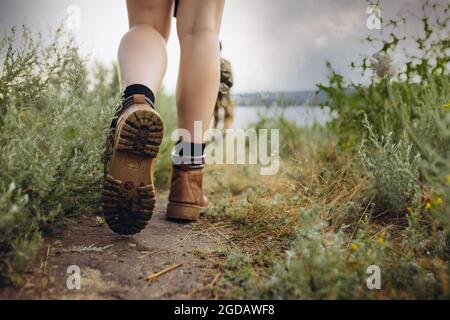 Nahaufnahme Beine von Touristen, Mann zu Fuß auf schmalen Weg im Sommerwald, Wiese. Aktiver Lebensstil, Freundschaft, Pflege, Ökologie Konzept Stockfoto