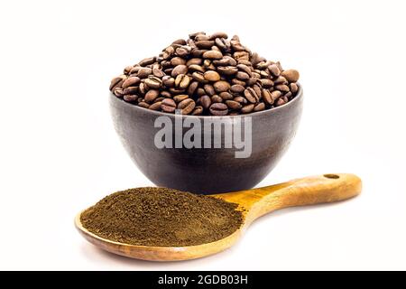 Kaffeepulver mit brasilianischen Kaffeesamen in Tonschüssel isoliert auf weißem Hintergrund. Stockfoto
