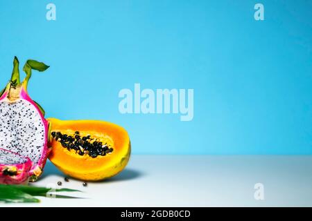 Zwei Hälften frische Bio-Drachenfrucht auf blauem Hintergrund, kreatives Sommer-Food-Konzept, Bannerhintergrund mit Kopierfläche, Minimalismus Trendy Food, Stockfoto