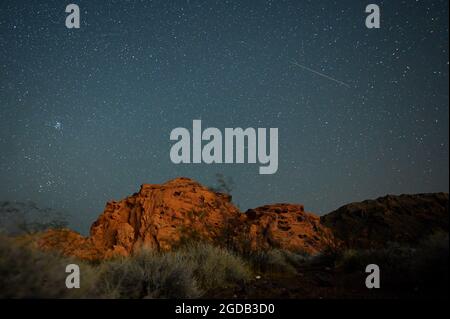 12. August 2021 - Lake Mead National Recreation Area, Nevada, USA - AM 12. August 2021 STREIFTE EIN Perseid-Meteor über den Himmel über dem Redstone Dune Trail im Lake Mead National Recreation Area. Die jährliche Anzeige, die als Perseiden-Schauer bekannt ist, weil die Meteore aus dem Sternbild Perseus am nordöstlichen Himmel zu strahlen scheinen, ist ein Ergebnis der Erdumlaufbahn, die durch Trümmer des Kometen Swift-Tuttle geht. (Bild: © David Becker/ZUMA Press Wire) Stockfoto