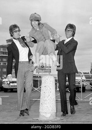 Foto vom 2/9/1970 von Una Stubbs springt am Flughafen Heathrow über einen Poller, unterstützt von den anderen Entertainern Hank Marvin (links) und Cliff Richard. Die Schauspielerin, die für ihre Rollen in TV-Serien wie Worzel Gummidge, Till Death US Do Part, Sherlock und EastEnders bekannt ist, ist im Alter von 84 Jahren gestorben. Ausgabedatum: Donnerstag, 12. August 2021. Stockfoto