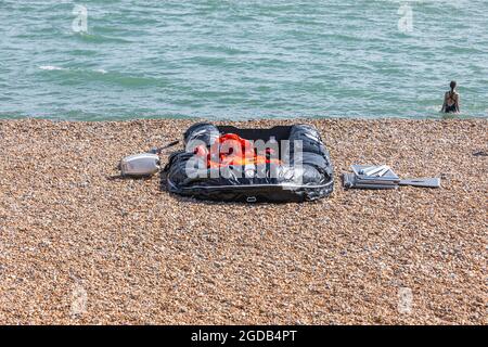 Ein Schlauchboot, das von illegalen Einwanderern/Asylbewerbern am Hythe Beach, Kent, aufgegeben wurde. Stockfoto