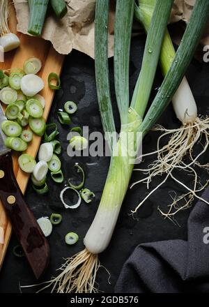 Frische Negi, Japanische Frühlingszwiebeln, gehackte Scallions auf Holzschneidebret, Flat Lay Kitchen Konzept. Stockfoto