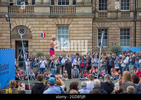 Royal Mile, Edinburgh, Schottland, Großbritannien. August 2021. Edinburgh Fringe Festival, Tag sieben des Geschehens auf der Hauptstadt High Street Veranstaltung. Das Wetter ist windig und bewölkt mit einer Temperatur von 18 Grad, da die menschlichen Statuen und Straßenkünstler Menschenmassen auf ihre Plätze ziehen. Im Bild: Kwabana Lindsay unterhält ein großes Publikum auf dem Parlimnet Square. Quelle: Arch White/Alamy Live News Stockfoto