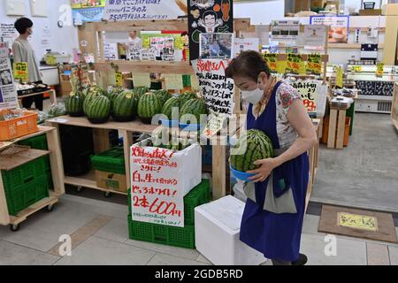 Tokio, Japan. August 2021. Impressionen aus Tokio. Verkäuferin, Frau mit Gesichtsmaske, Maske an einem Obst- und Gemüsestand Credit: dpa/Alamy Live News Stockfoto