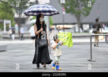 Tokio, Japan. August 2021. Impressionen aus Tokio. Junge Frau mit Kind und Regenschirm, gehen Sie über einen Ort. â Credit: dpa/Alamy Live News Stockfoto