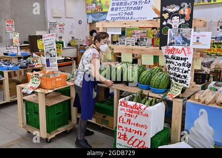 Tokio, Japan. August 2021. Impressionen aus Tokio. Verkäuferin, Frau mit Gesichtsmaske, Maske an einem Obst- und Gemüsestand Credit: dpa/Alamy Live News Stockfoto