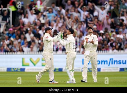 Der englische Jonny Bairstow (links) feiert mit den Teamkollegen Jos Buttler und Joe Root, nachdem er den Fang genommen hat, um den indischen Cheteshwar Pujara am ersten Tag des zweiten Test-Spiels in Lord's, London, zu entlassen. Bilddatum: Donnerstag, 12. August 2021. Stockfoto