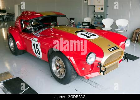 Oliver Bryant's, 1964, Red and Gold AC Cobra, parkte in der internationalen Pit-Garage beim Silverstone-Klassiker 2021 Stockfoto