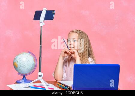 Online-Videokonferenz. Online-Training. Schulmädchen lernt aus der Ferne für Laptop und Smartphone. Konzept Stockfoto