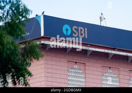 Blue State Bank of India SBI-Board auf dem rosafarbenen Gebäude, das Indiens größte Bank des öffentlichen Sektors zeigt, unter der sich PSU-Banken befinden Stockfoto